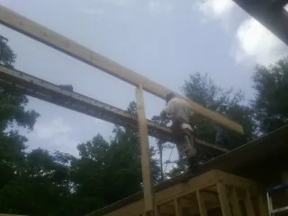 Carpenter setting a ridge beam over a new addition frame — Ice Dam Removal by Roofing Brothers in Orcas